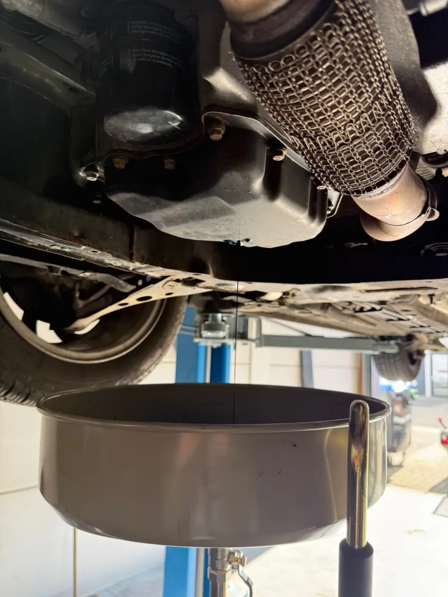Motorolie aftappen tijdens een onderhoudsbeurt bij Leermans Automotive in Nijkerk